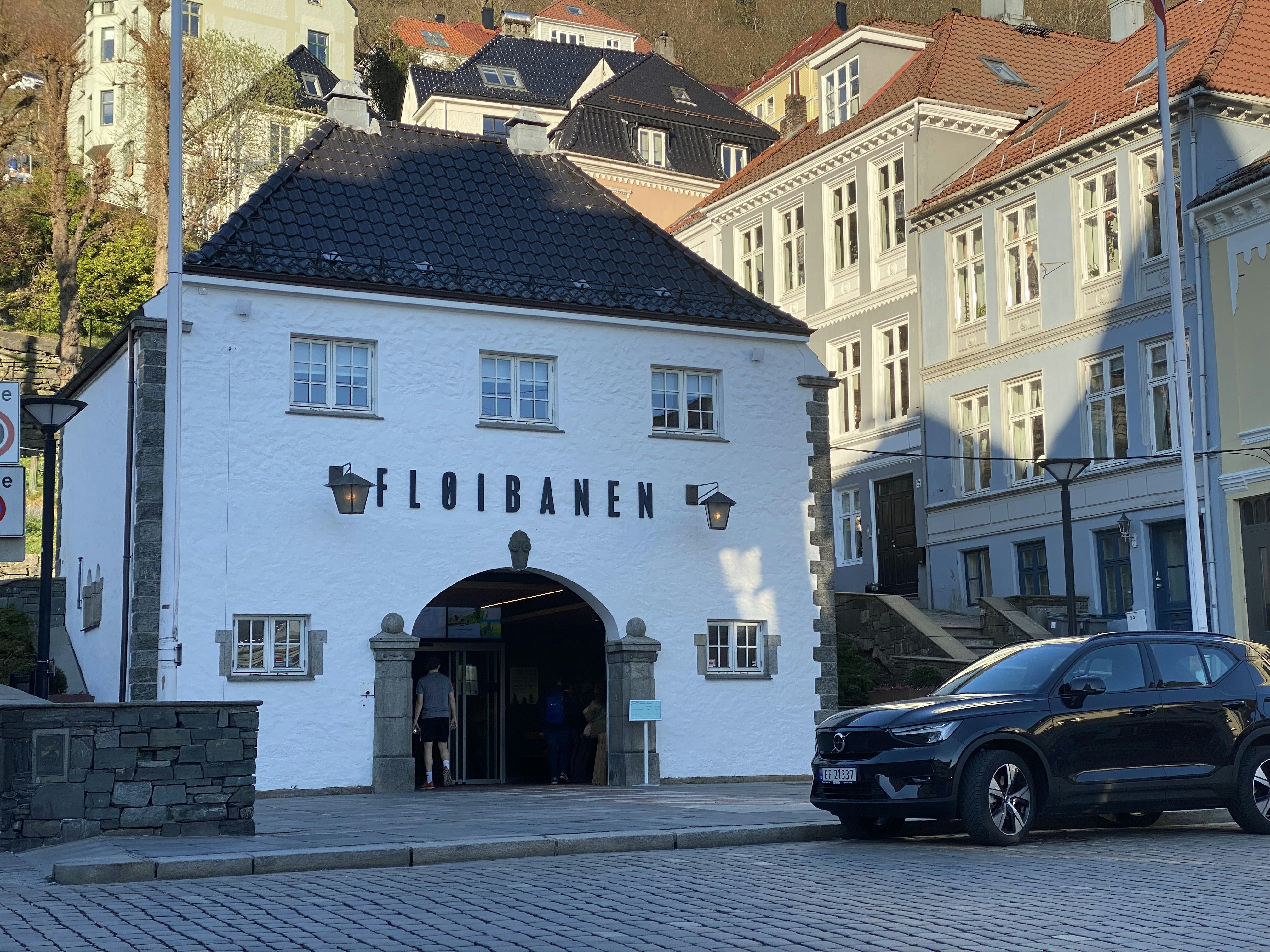 Ein schwarzes Auto parkt vor einem weißen Gebäude