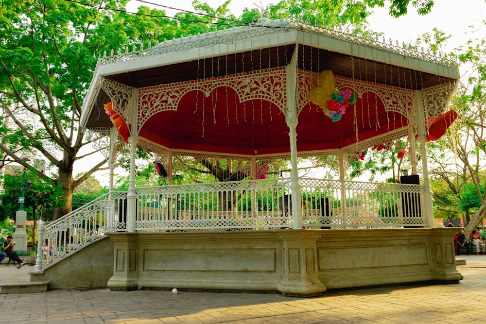 a white and red gazebo sitting on top of a sidewalk