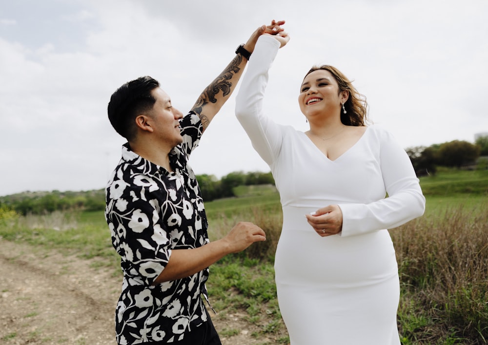 a woman in a white dress and a man in a black and white shirt