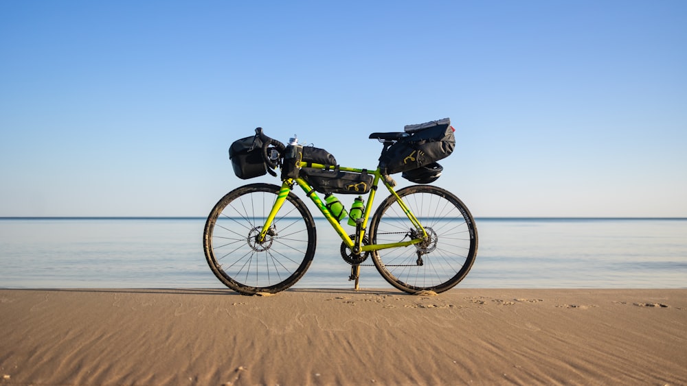 a bike parked on a beach next to the ocean
