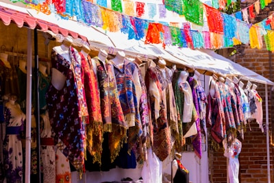 Colorful kurtas displayed on hangers with bright festival lights