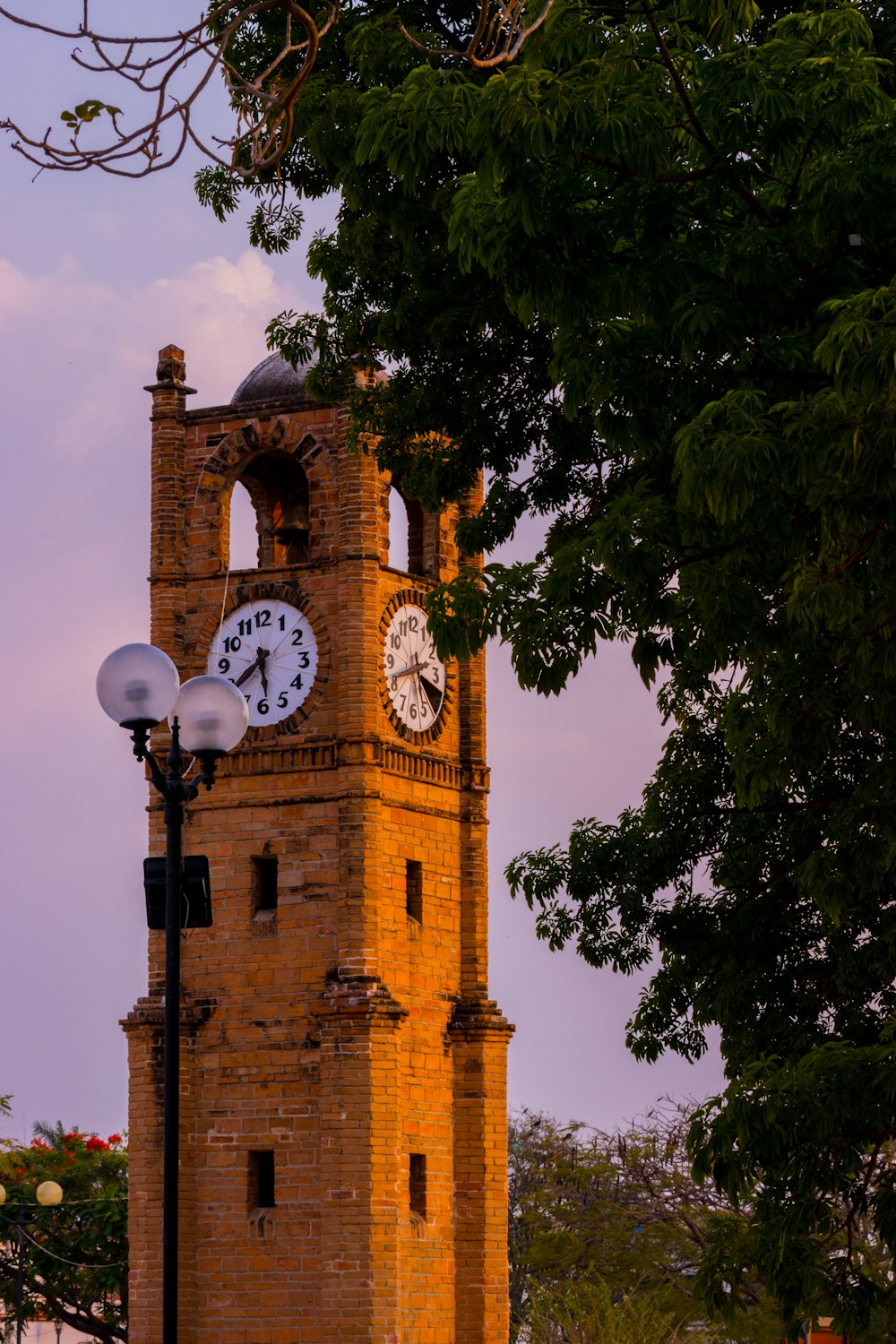 a tall brick clock tower with a clock on each of it's sides