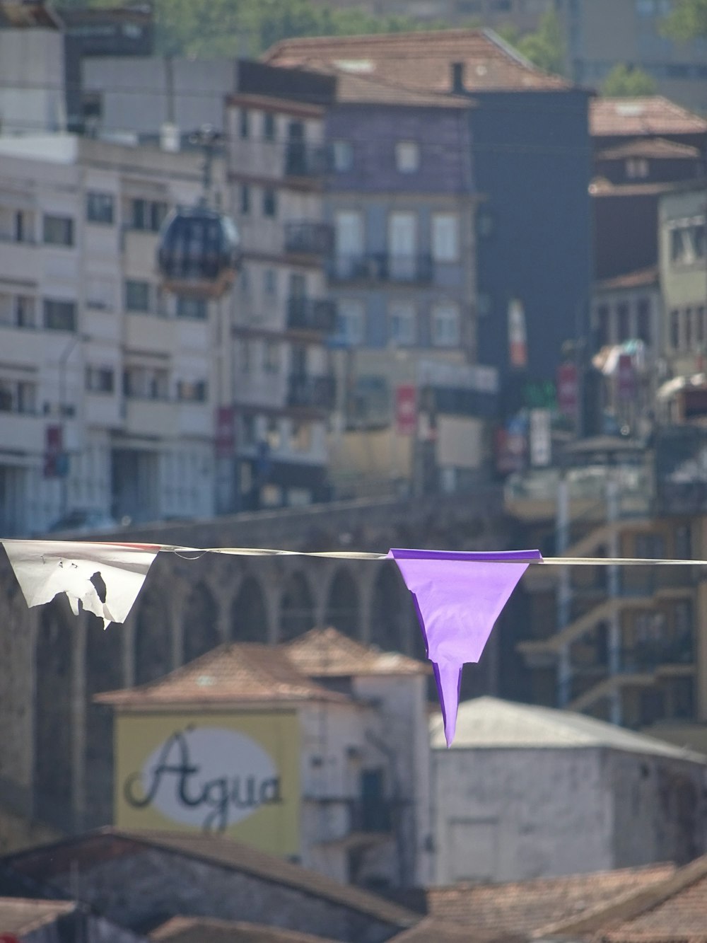 a purple kite hanging from a clothes line in a city