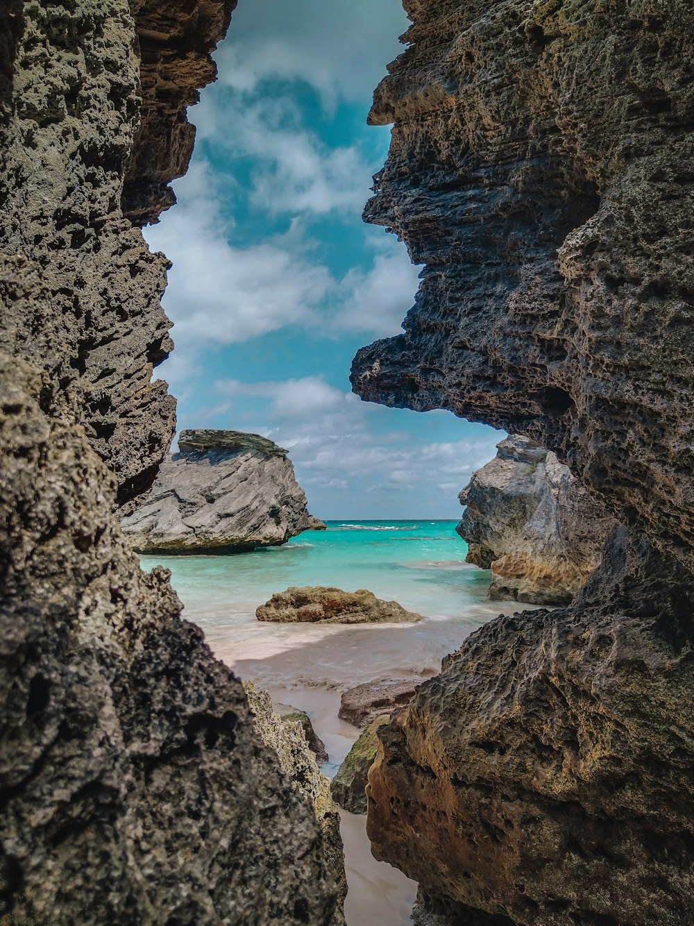 a view of the ocean through a rock arch