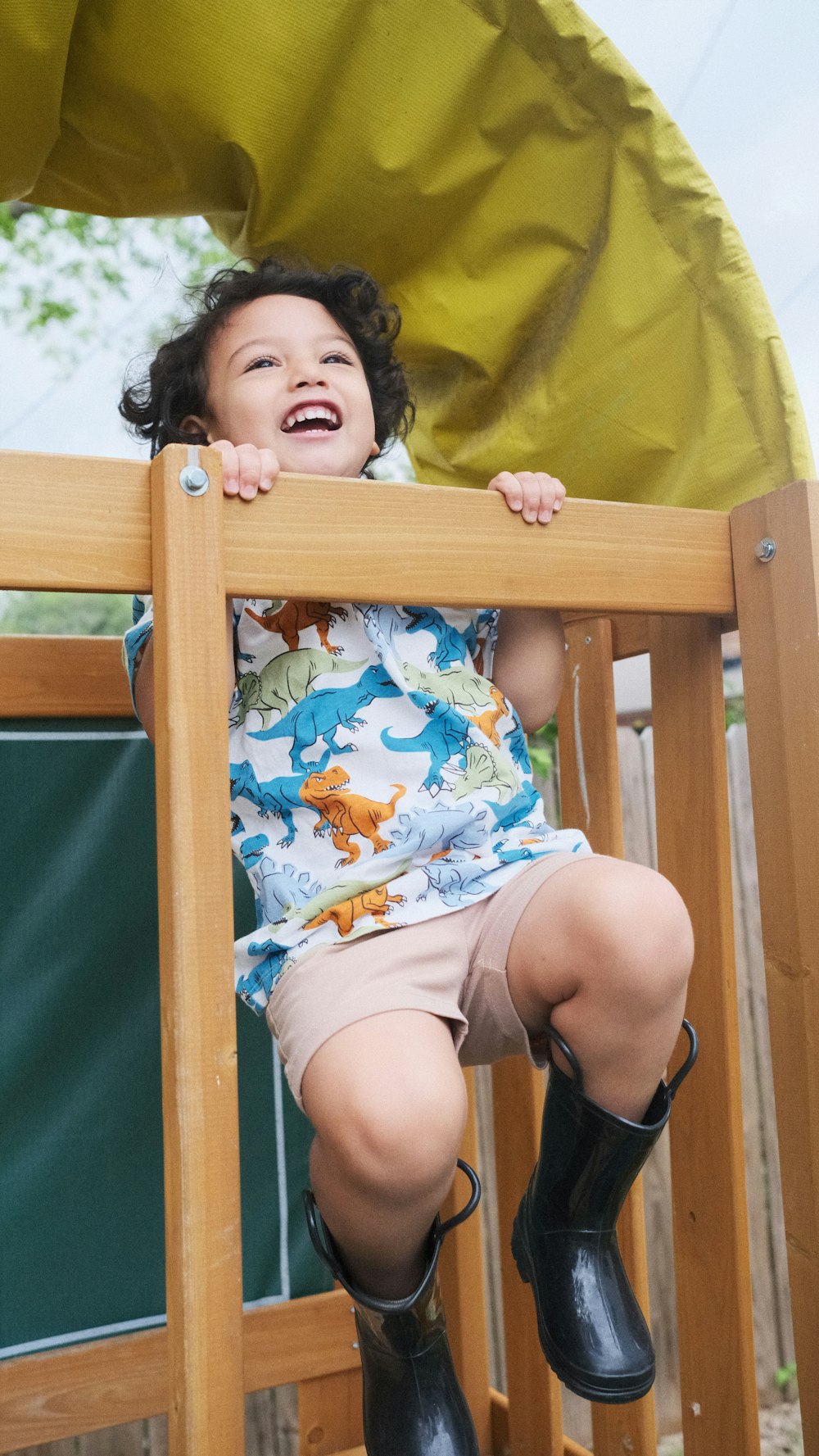 a little girl sitting on top of a wooden chair