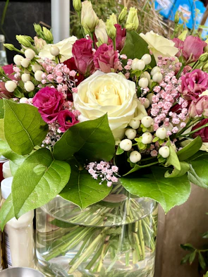 A vibrant bouquet of hybrid roses in a vase, enhanced by the natural scent spray.