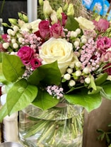 a vase filled with lots of flowers on top of a table
