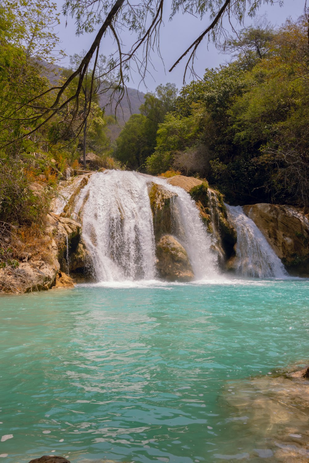 a waterfall with a blue pool in the middle of it