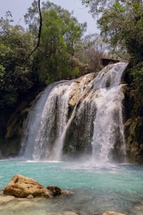 a large waterfall with a small waterfall in the middle of it