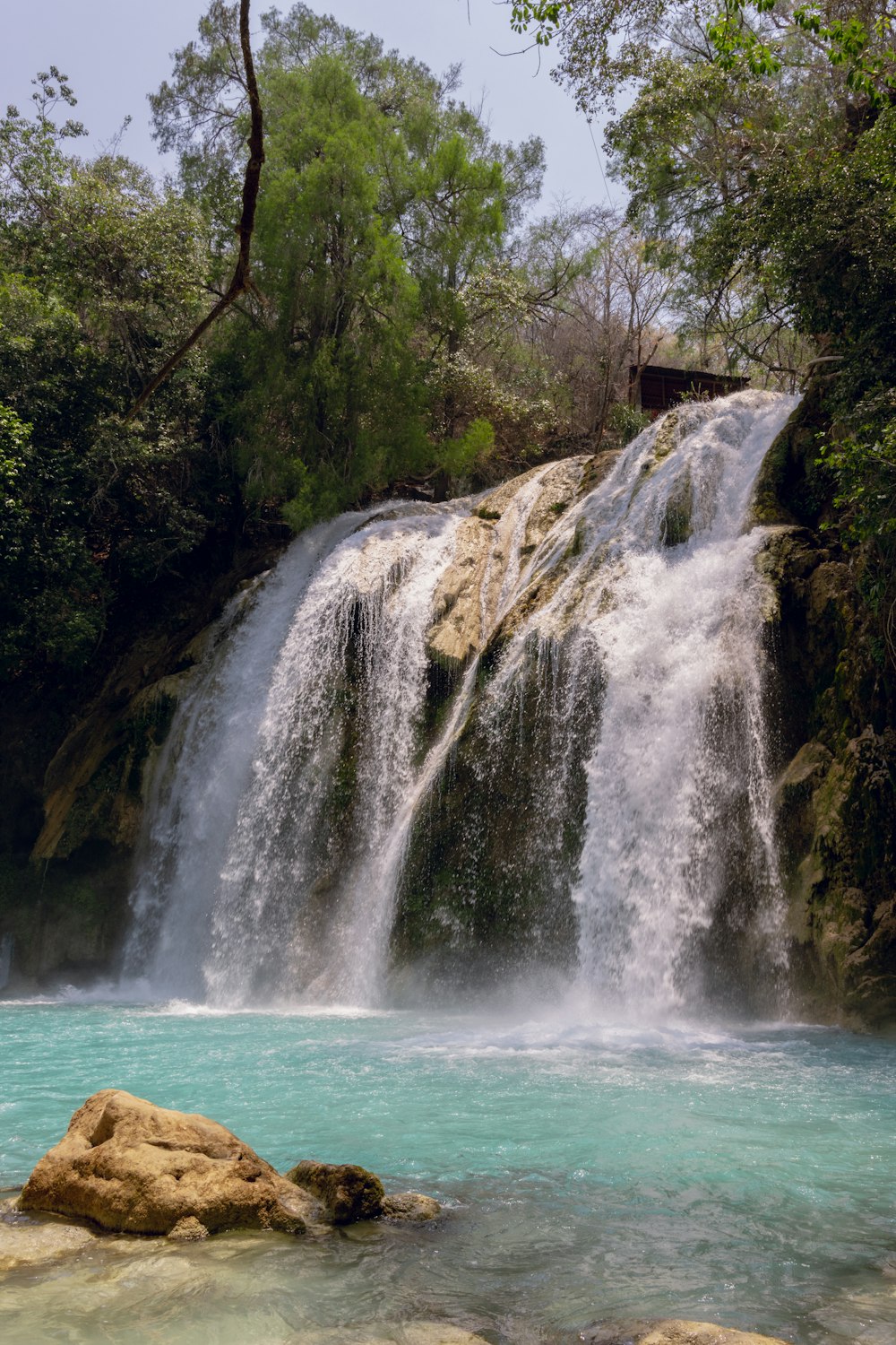 a large waterfall with a small waterfall in the middle of it