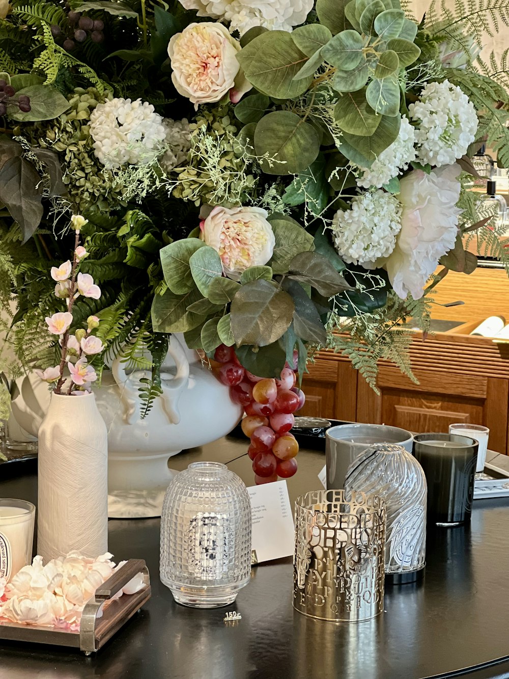a table topped with vases filled with flowers and fruit