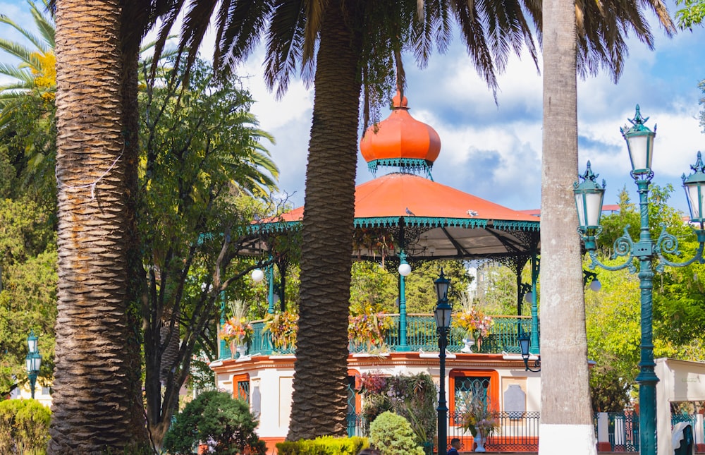 a gazebo surrounded by palm trees on a sunny day