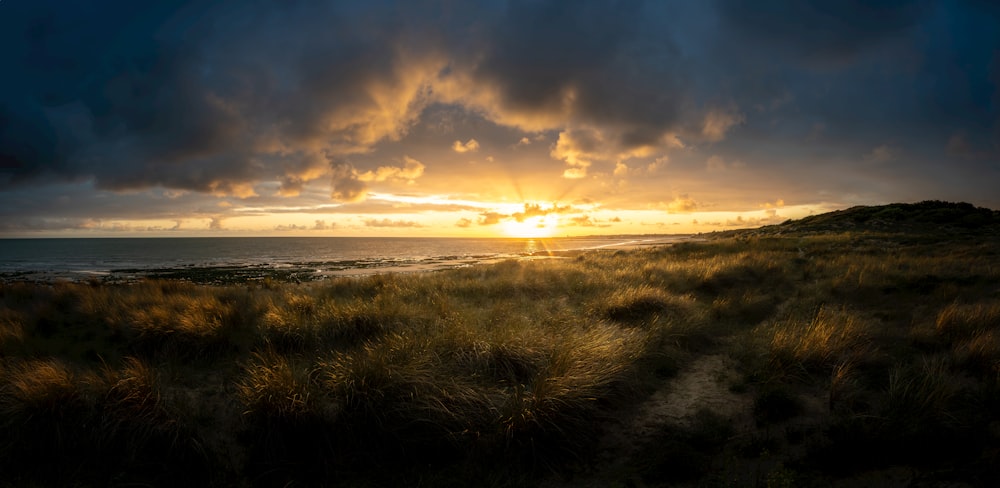 Il sole sta tramontando sull'oceano in una giornata nuvolosa