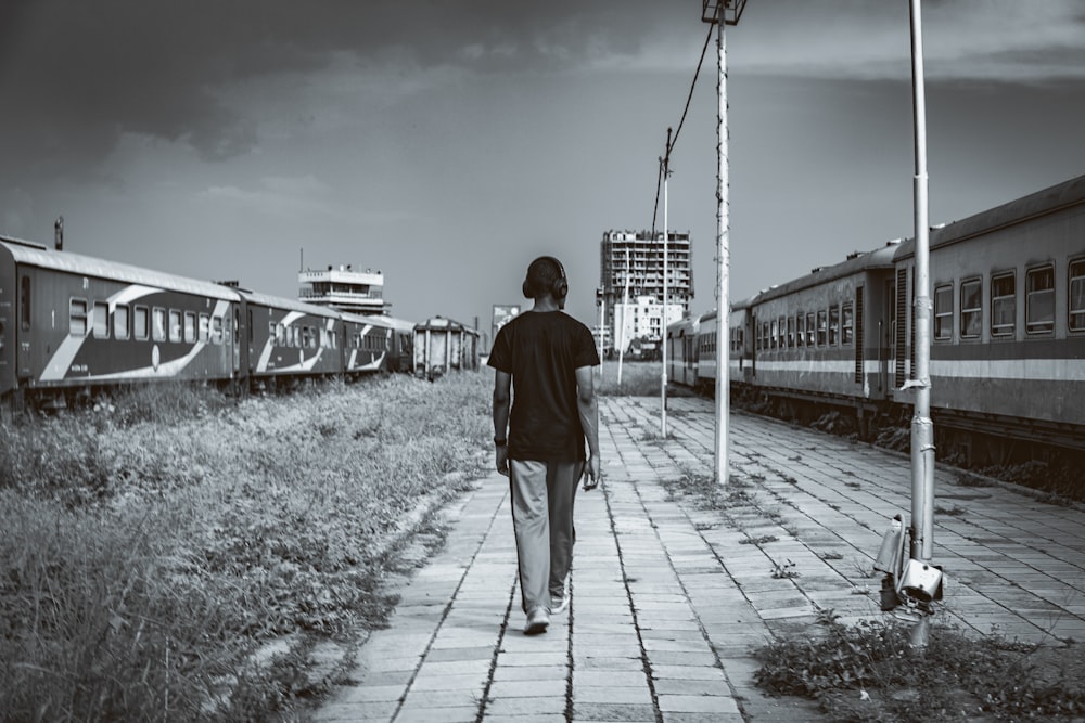 Ein Mann, der neben einem Zug einen Bürgersteig entlang geht