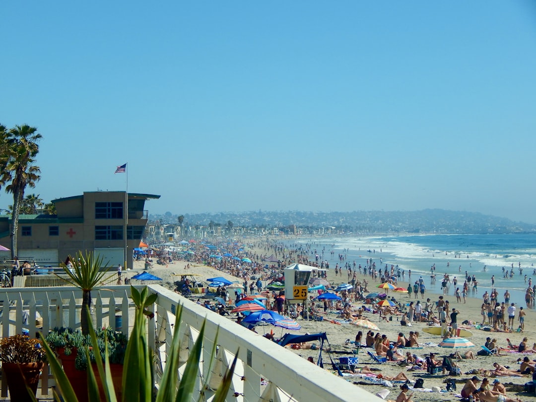 a crowded beach with a lot of people on it, A sunny day at Pacific Beach packed with people enjoying a beautiful day in 