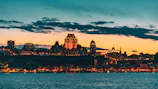 A cinematic shot of a city skyline at dusk with warm lighting.