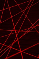Red laser beams crisscross against a dark background, creating an intricate web of intersecting lines.