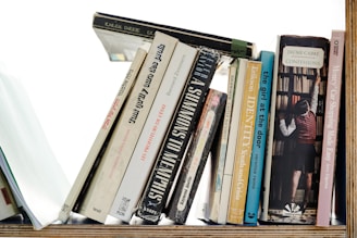 a bookshelf filled with lots of books on top of a wooden shelf