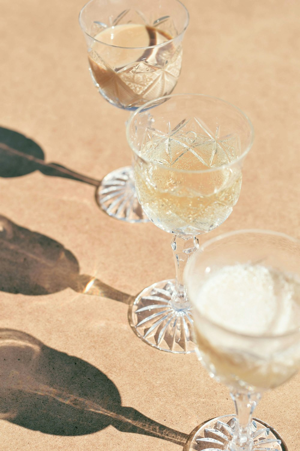 three wine glasses sitting on top of a table