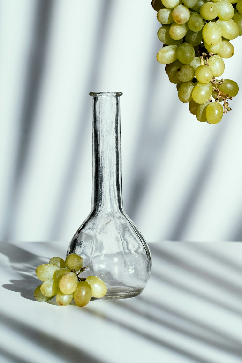 a glass vase with some grapes in it