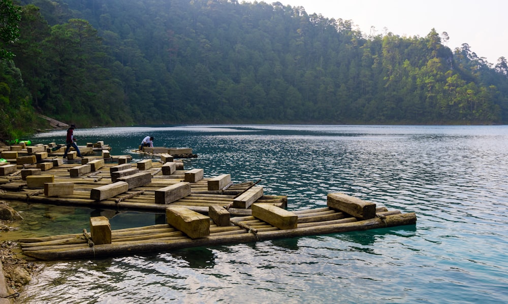 a group of people standing on wooden rafts in the water