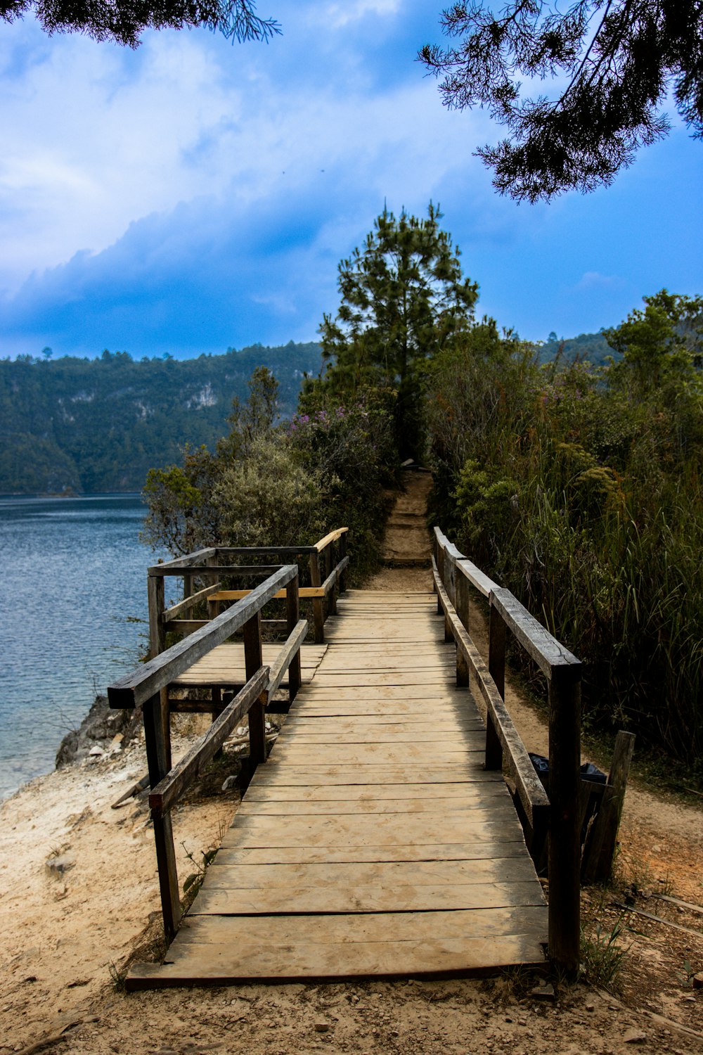 a wooden walkway leading to the water on a beach