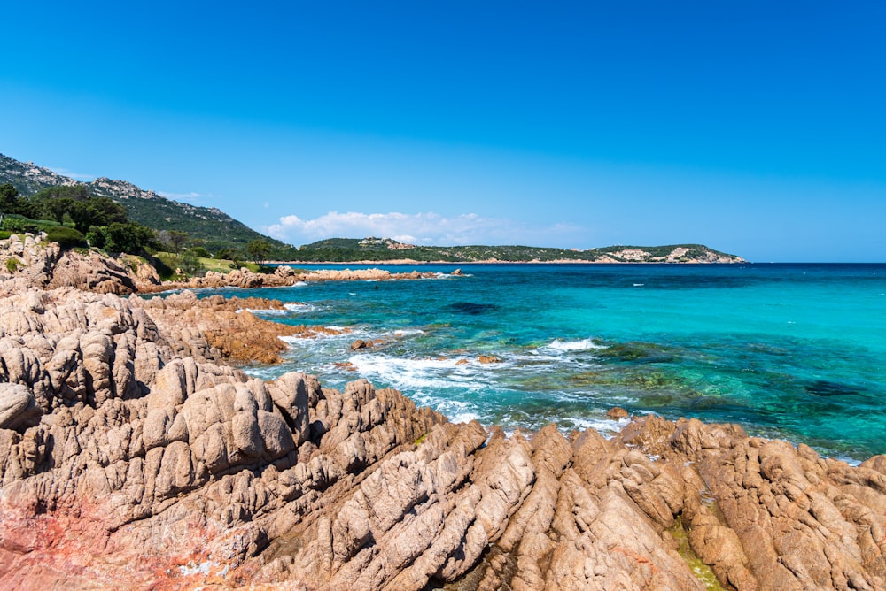 a rocky beach with clear blue water