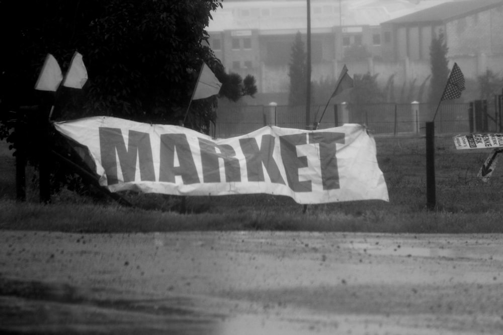 a black and white photo of a market sign