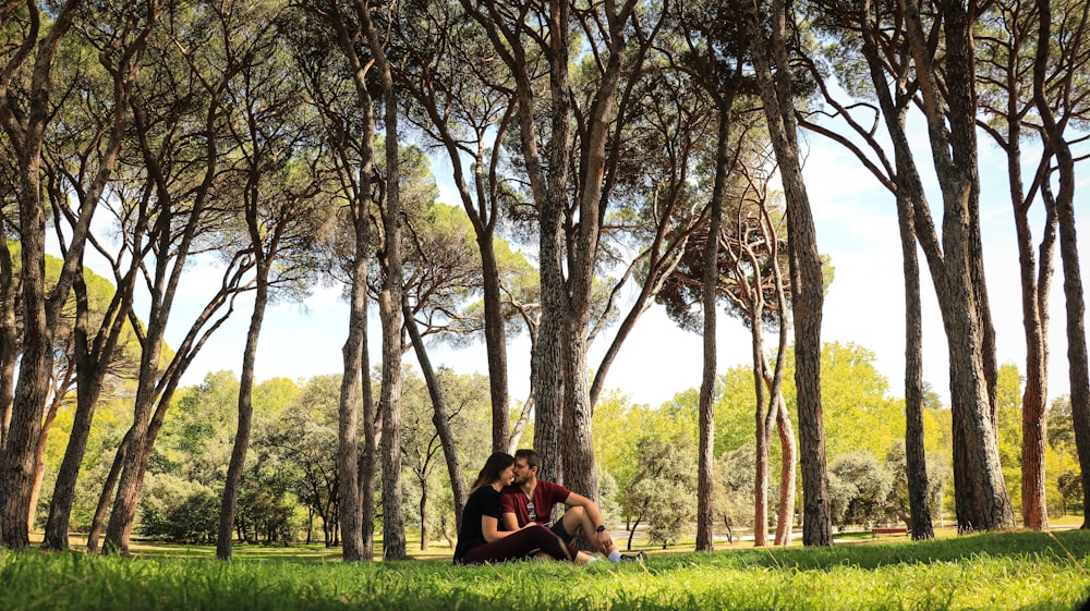 a man and woman sitting on a bench in a park