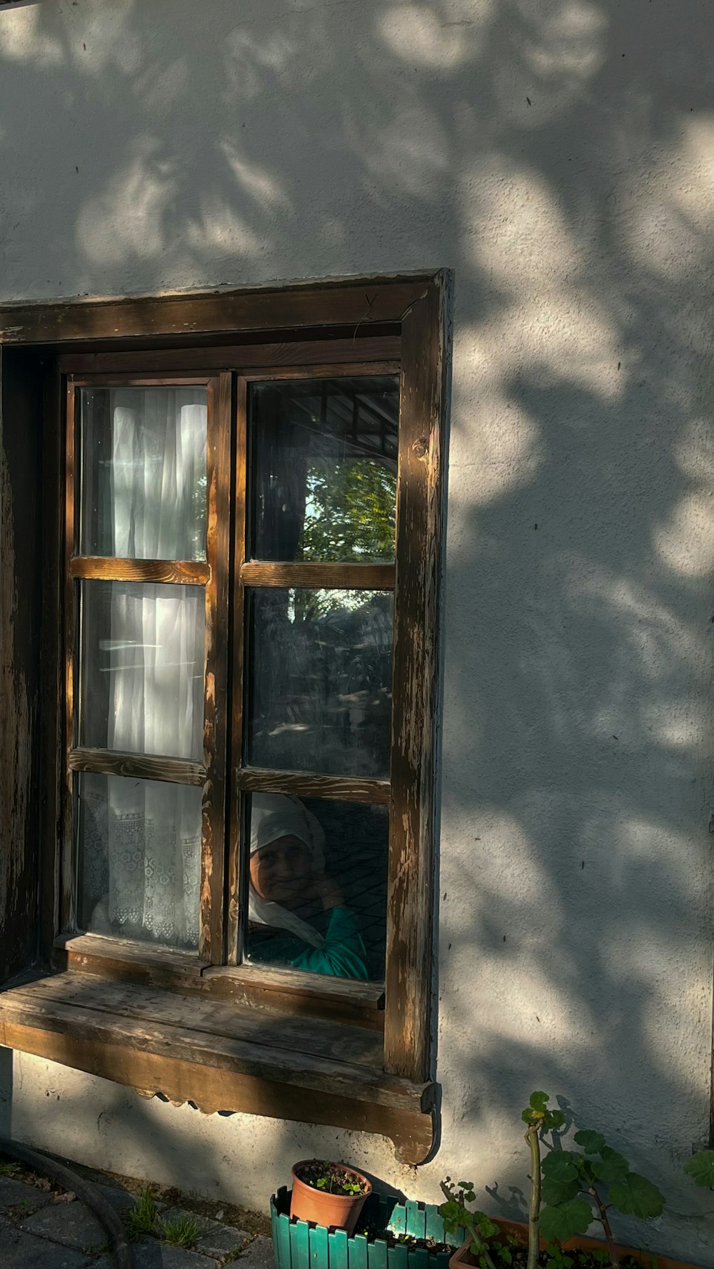 eine Person, die aus dem Fenster eines Hauses schaut