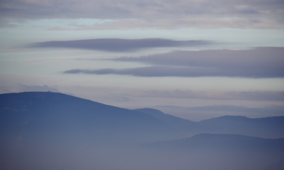 A serene misty blue landscape with soft cream accents.