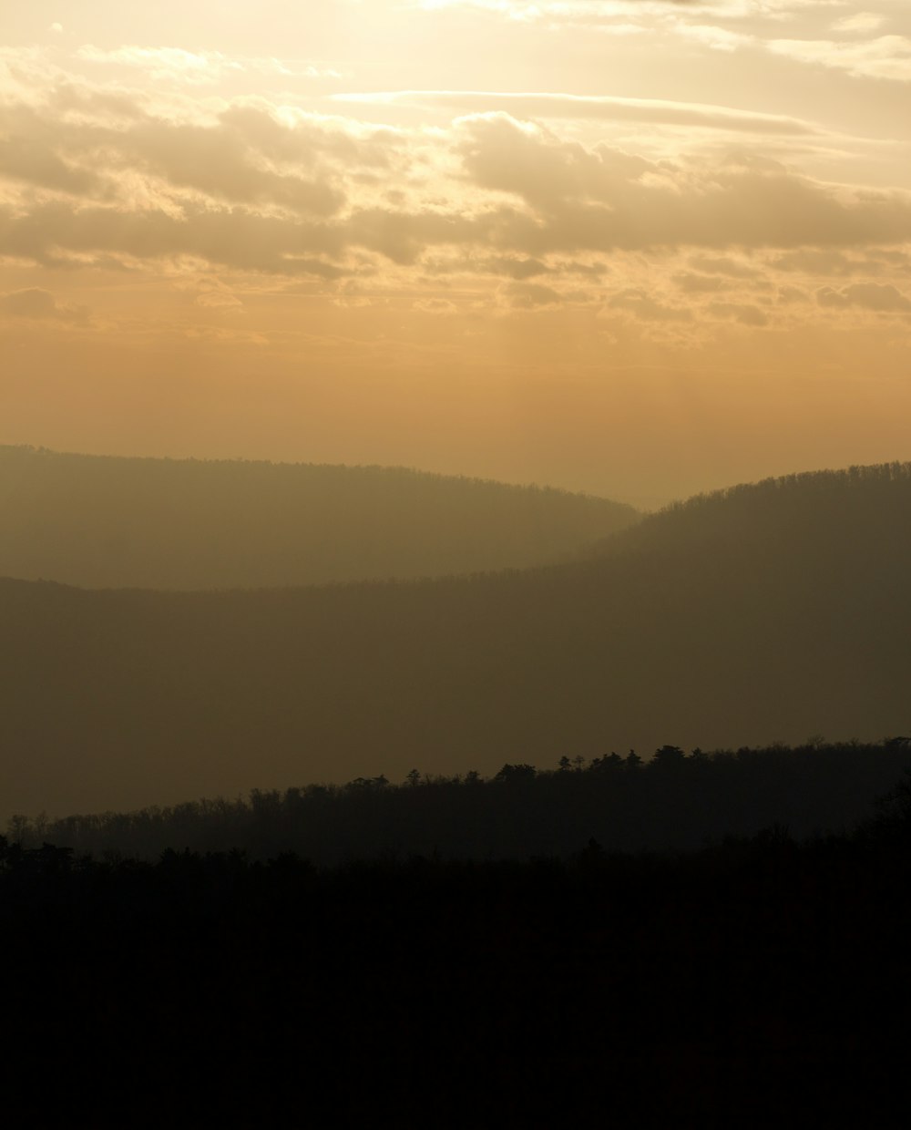 Die Sonne geht über den Bergen in der Ferne unter