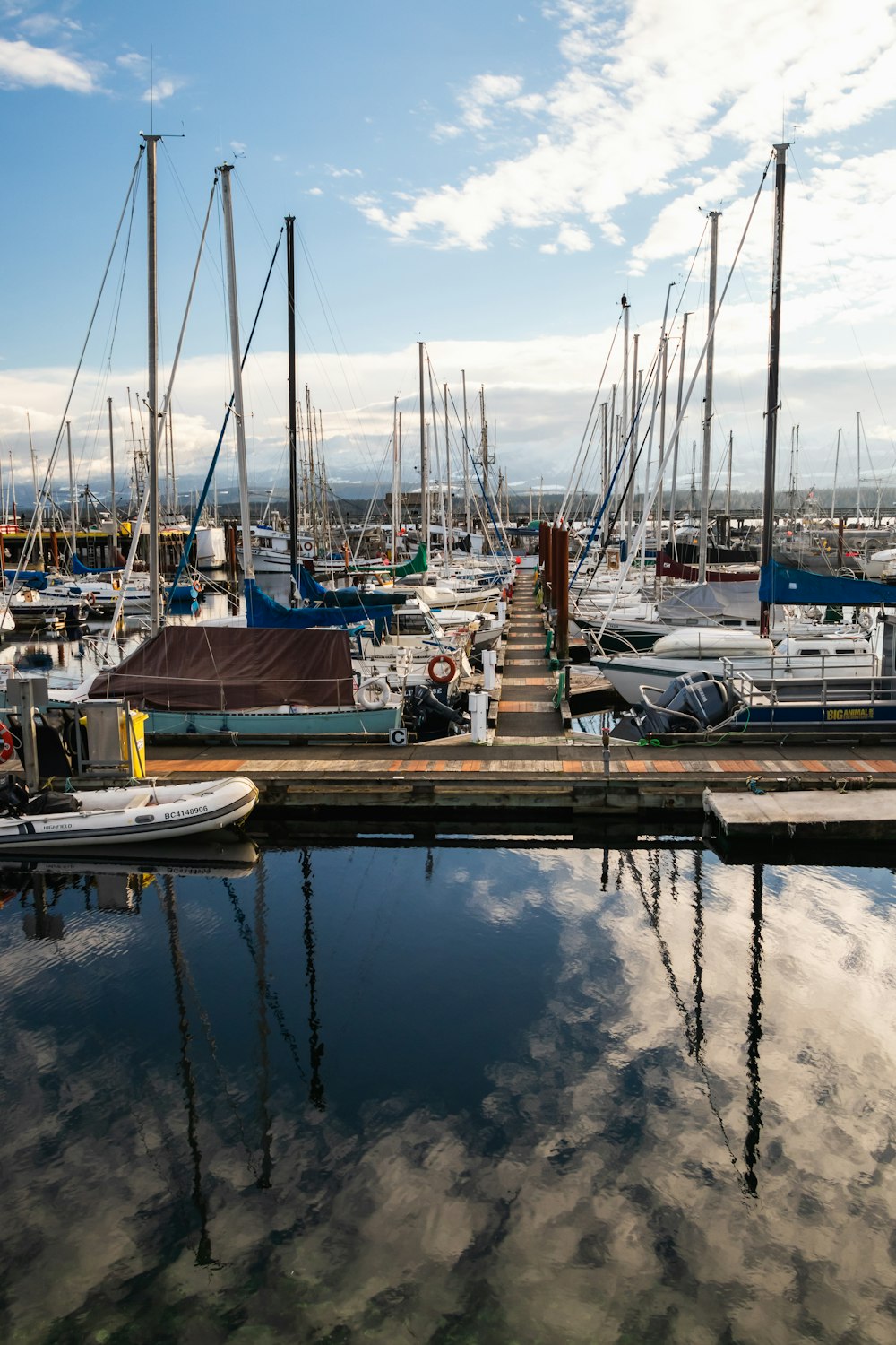 a marina filled with lots of boats under a cloudy blue sky