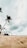 a man standing on top of a sandy beach next to a palm tree
