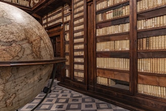 a room filled with lots of books and a giant globe