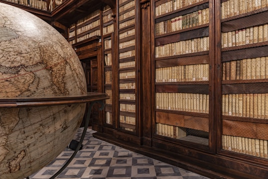 a room filled with lots of books and a giant globe