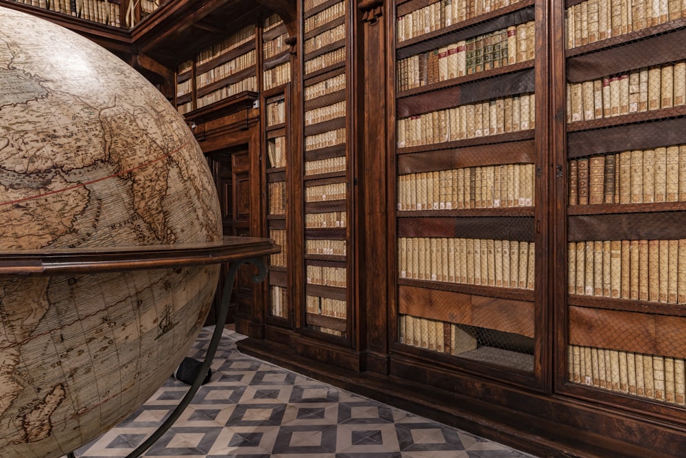a room filled with lots of books and a giant globe