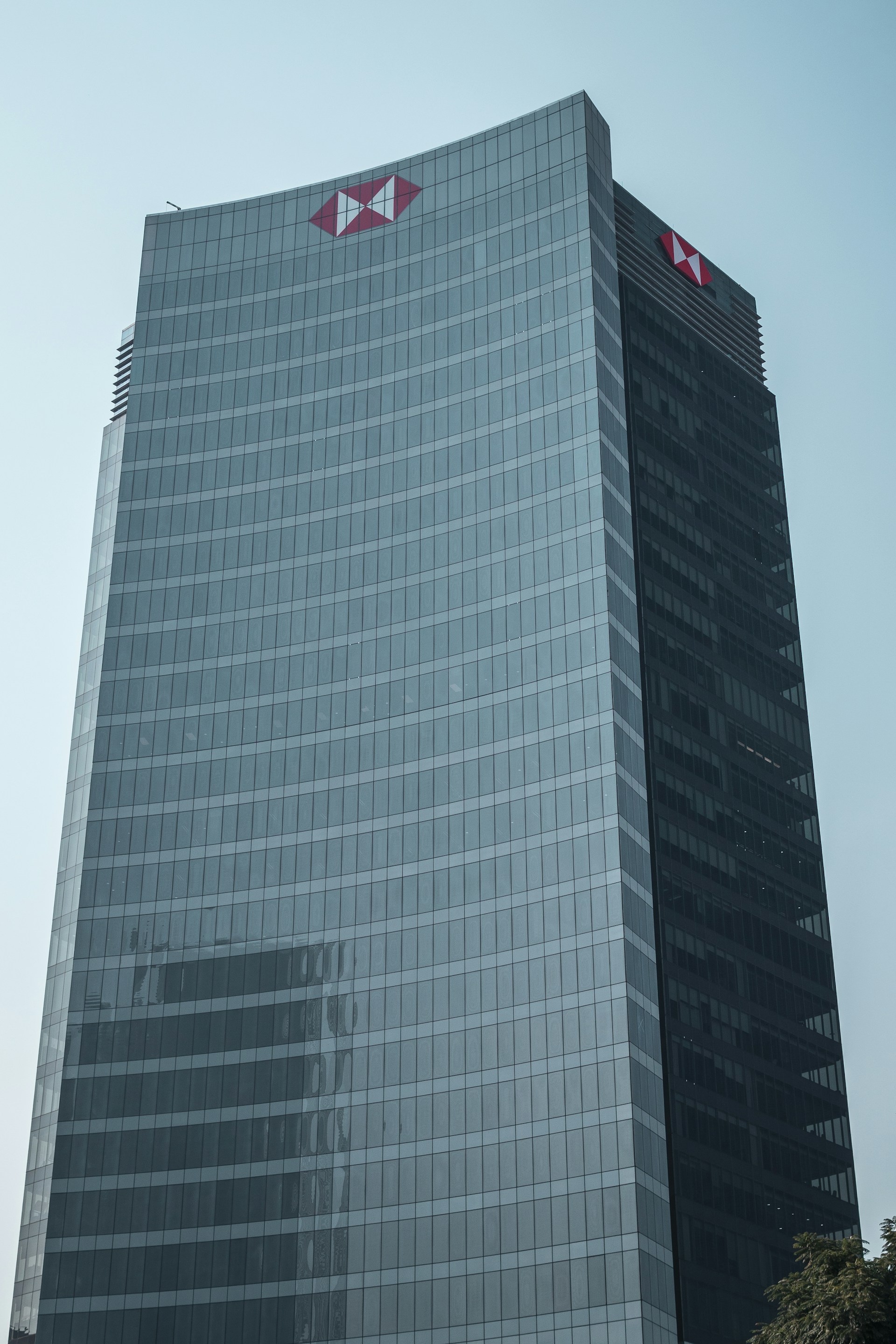 a very tall building with a red logo on it