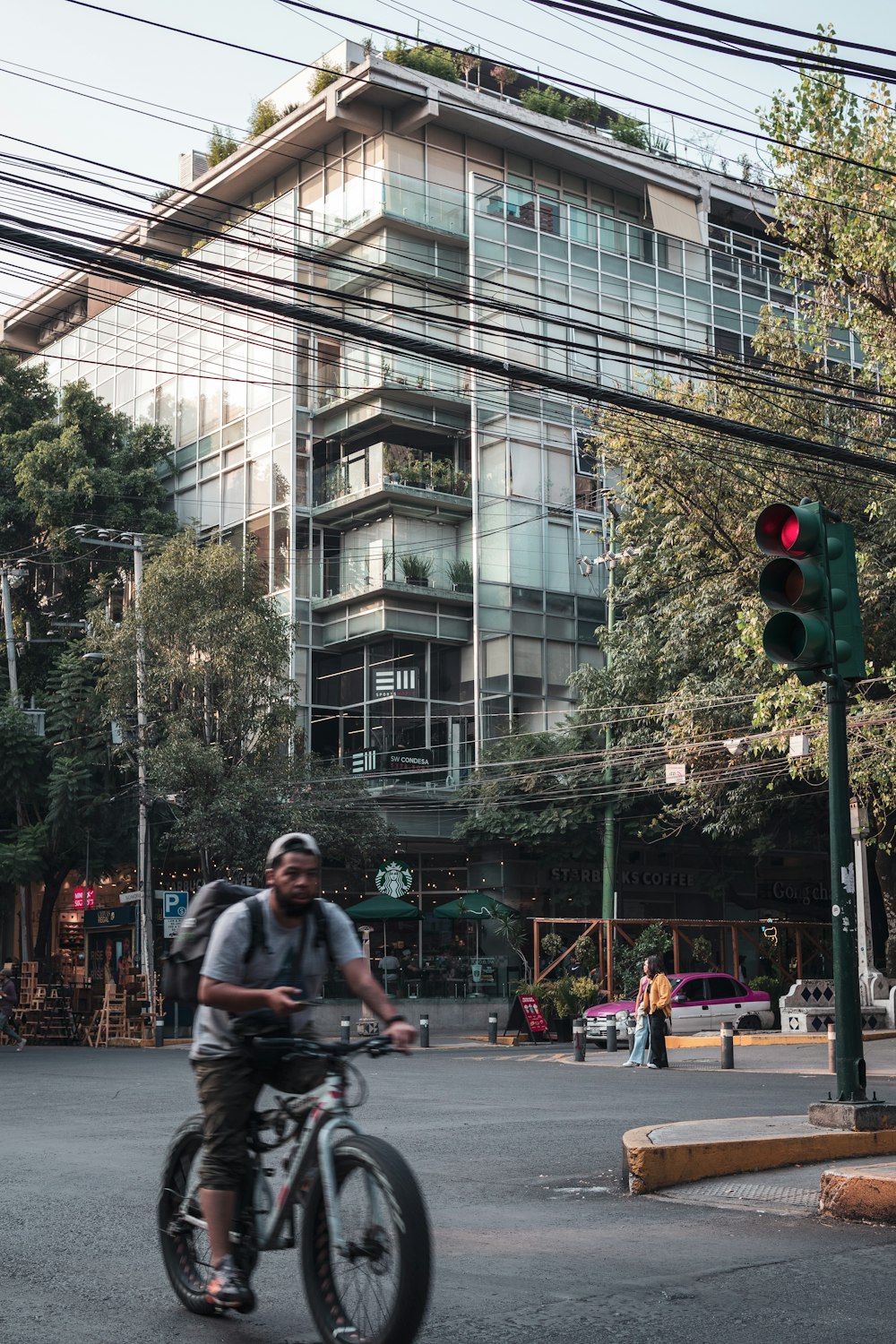 a man riding a bike down a street next to a traffic light