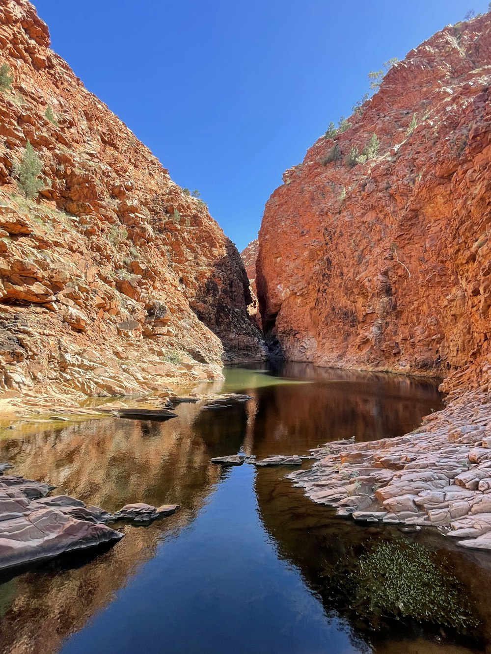 a body of water surrounded by red rocks