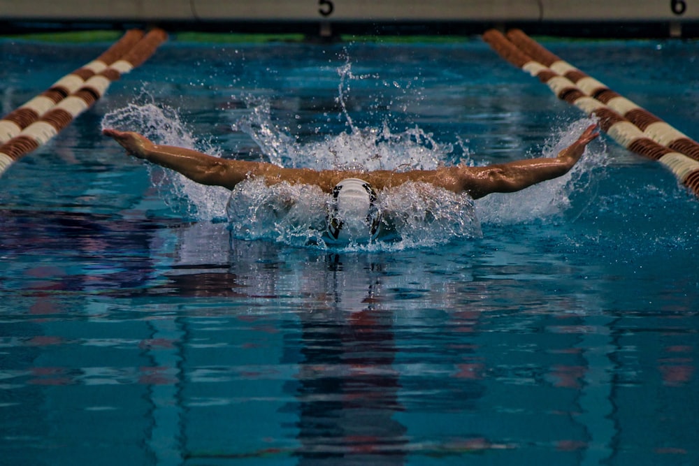 a man swimming in a pool with a swimming board