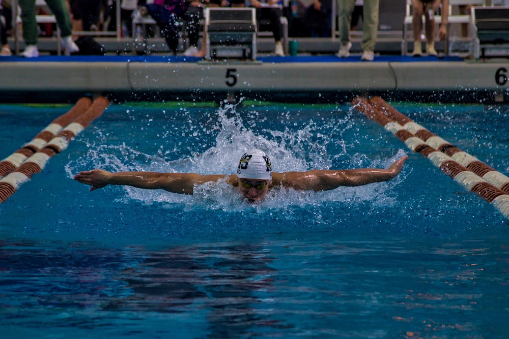 a man swimming in a pool during a competition