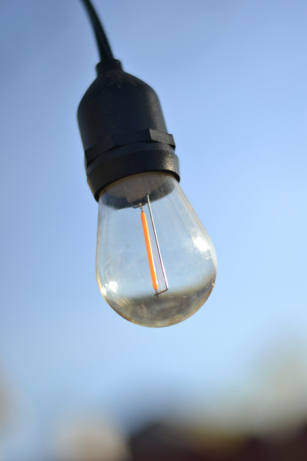 a light bulb hanging from a black wire
