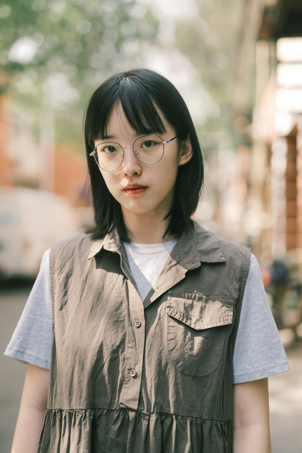 a woman with glasses standing on a street