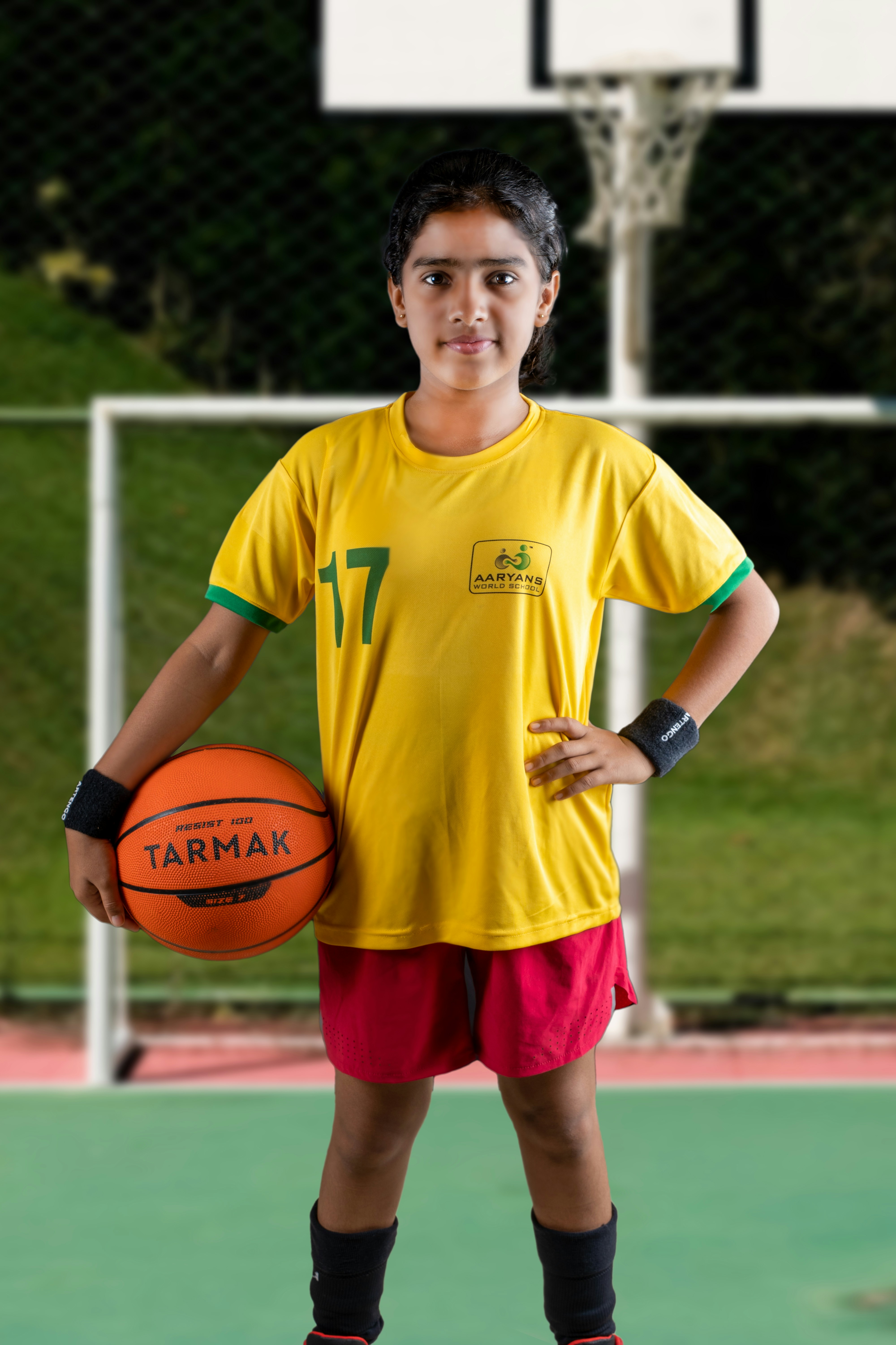 a young boy holding a basketball on a basketball court