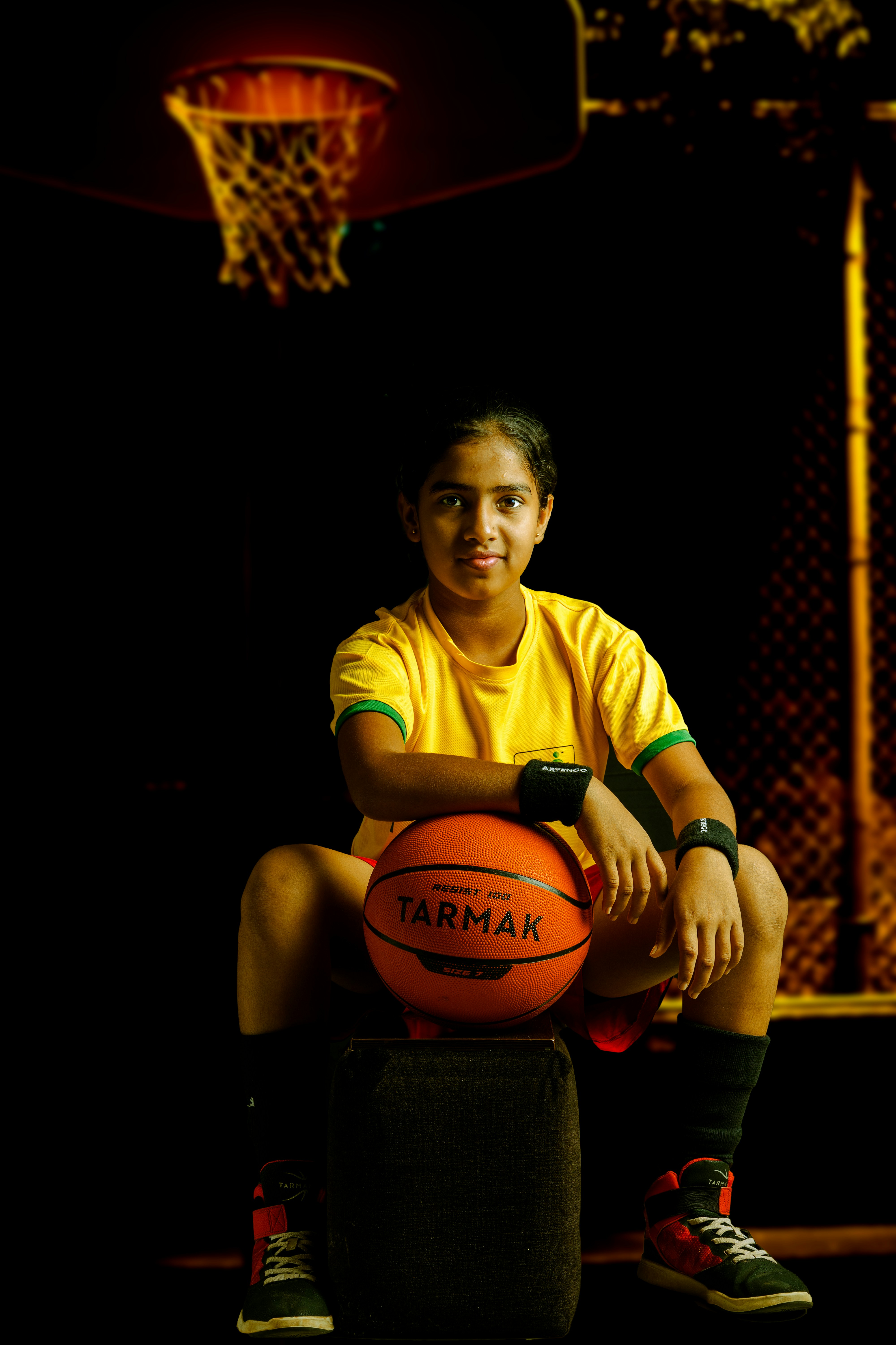 a young man sitting on top of a basketball