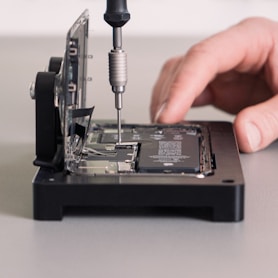 a person working on a device with a screwdriver