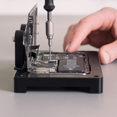 a person working on a device with a screwdriver
