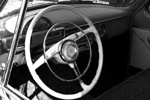 High contrast image of a vintage car dashboard taken from the driver’s perspective.