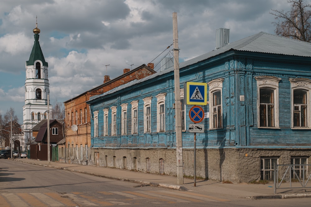 a blue building with a clock tower in the background